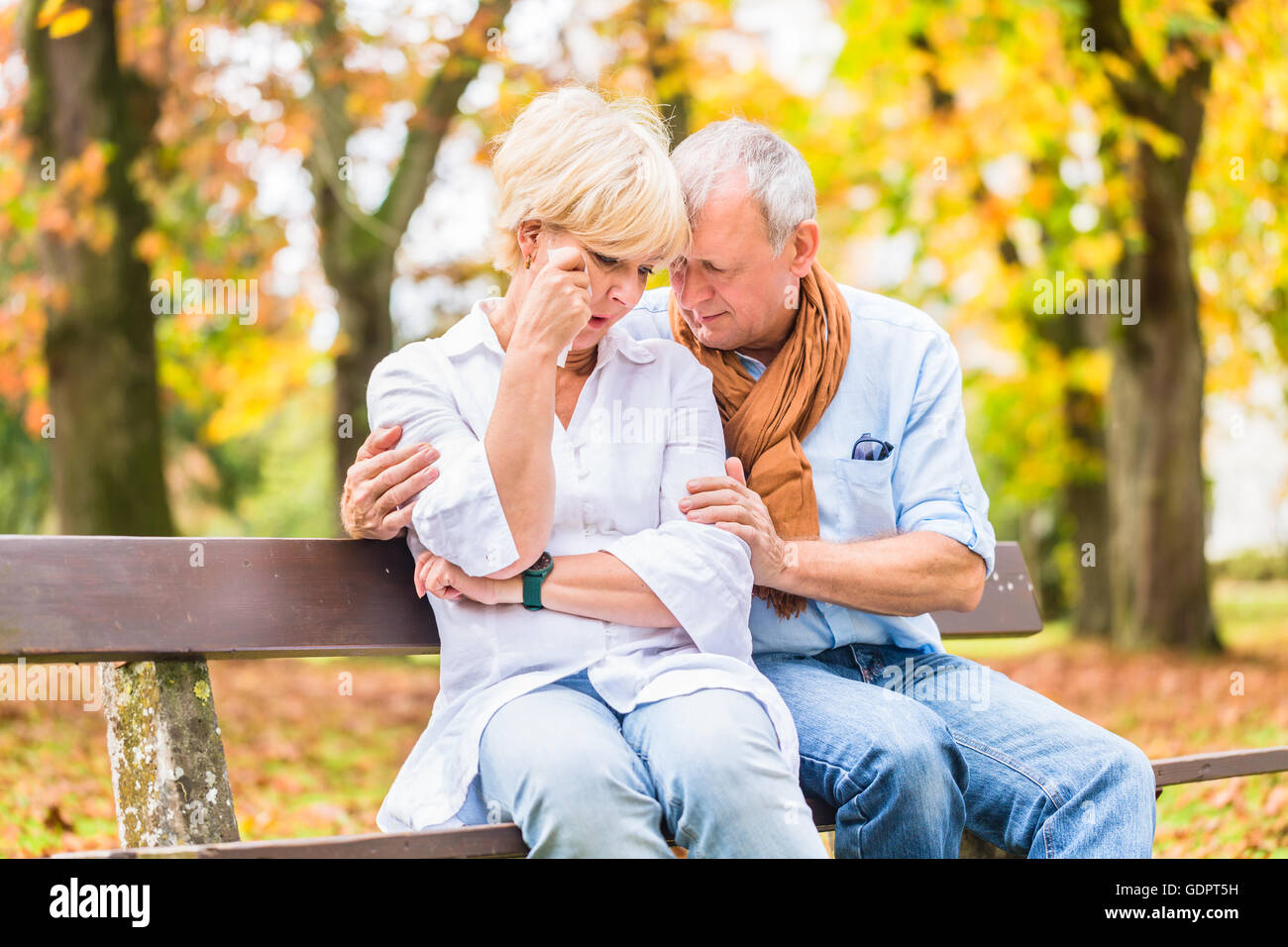 Senior man and woman having being sad embracing each other Stock Photo