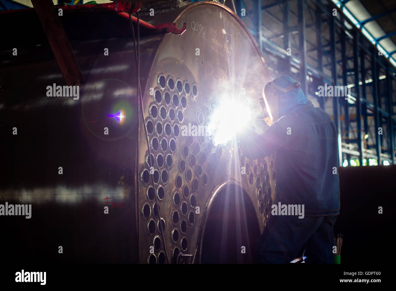 Welder working in an industrial setting manufacturing steel equipment Stock Photo