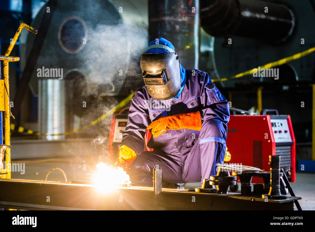 Welder working in an industrial setting manufacturing steel equipment