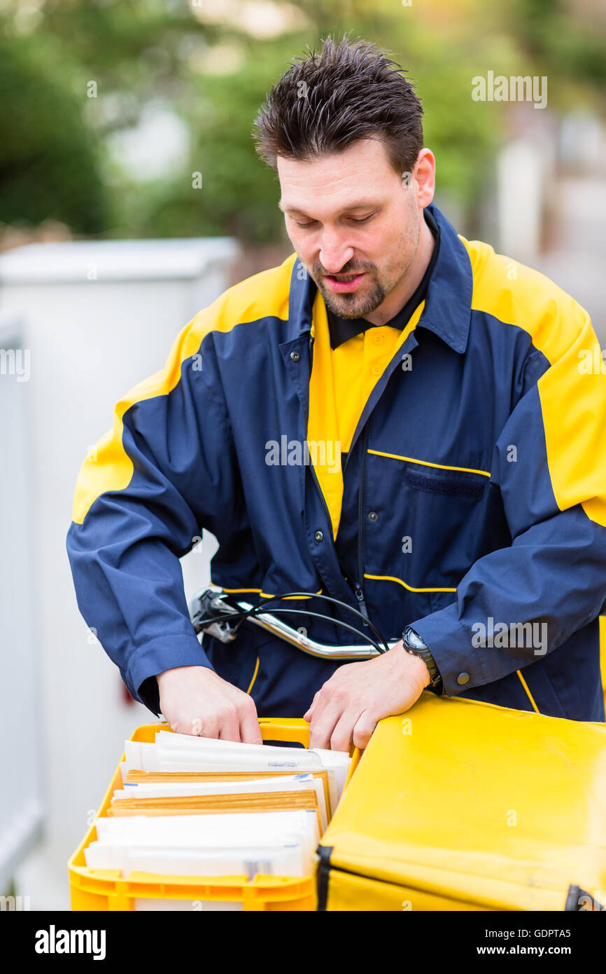 Postman Distributing Letters Postman delivering letters to mailbox of recipient Stock Photo - Alamy