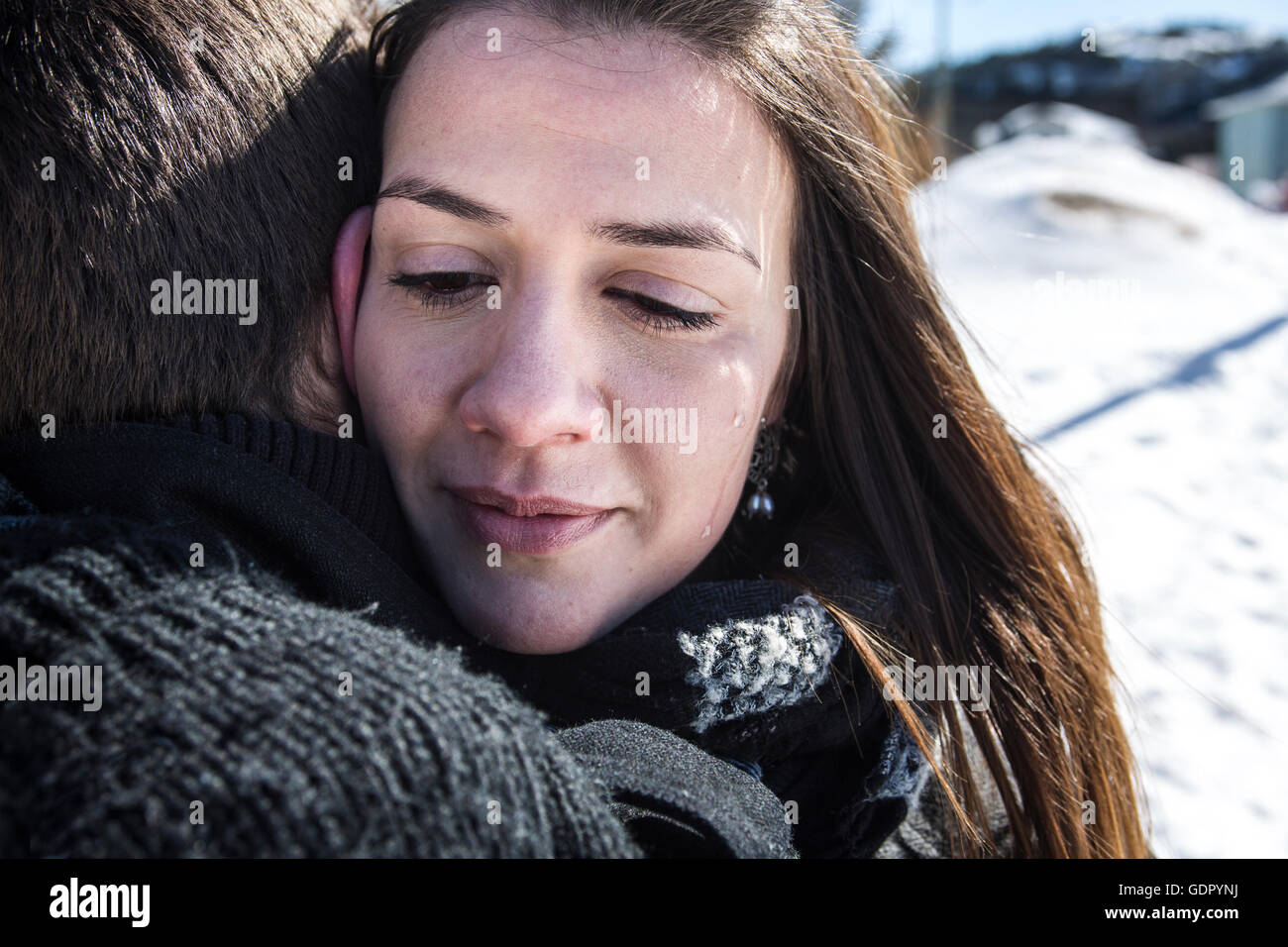 Woman crying near man in winter and wiping tear off her face Stock Photo