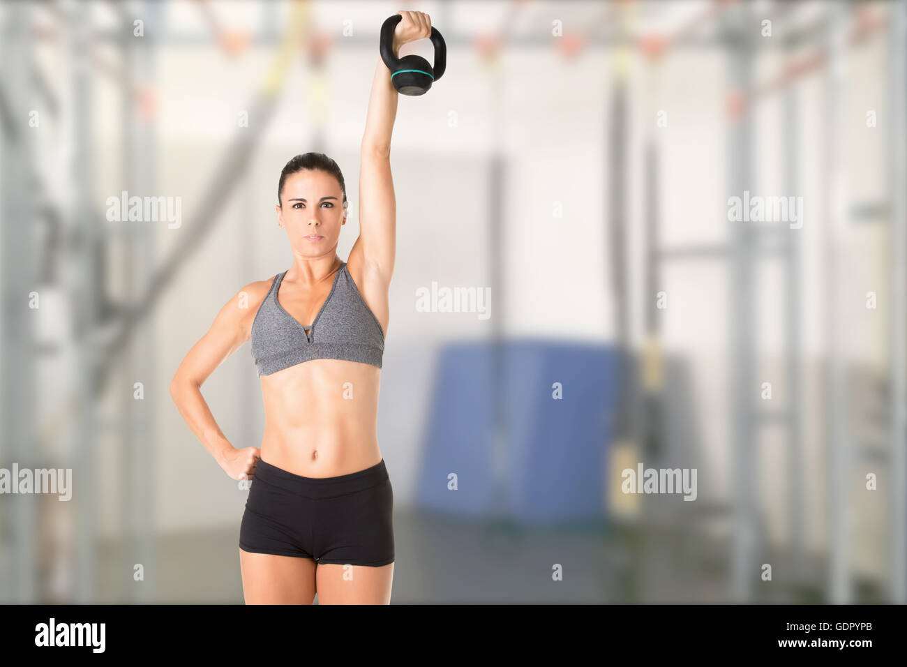 Fit woman working out with a kettlebell, isolated in grey Stock Photo