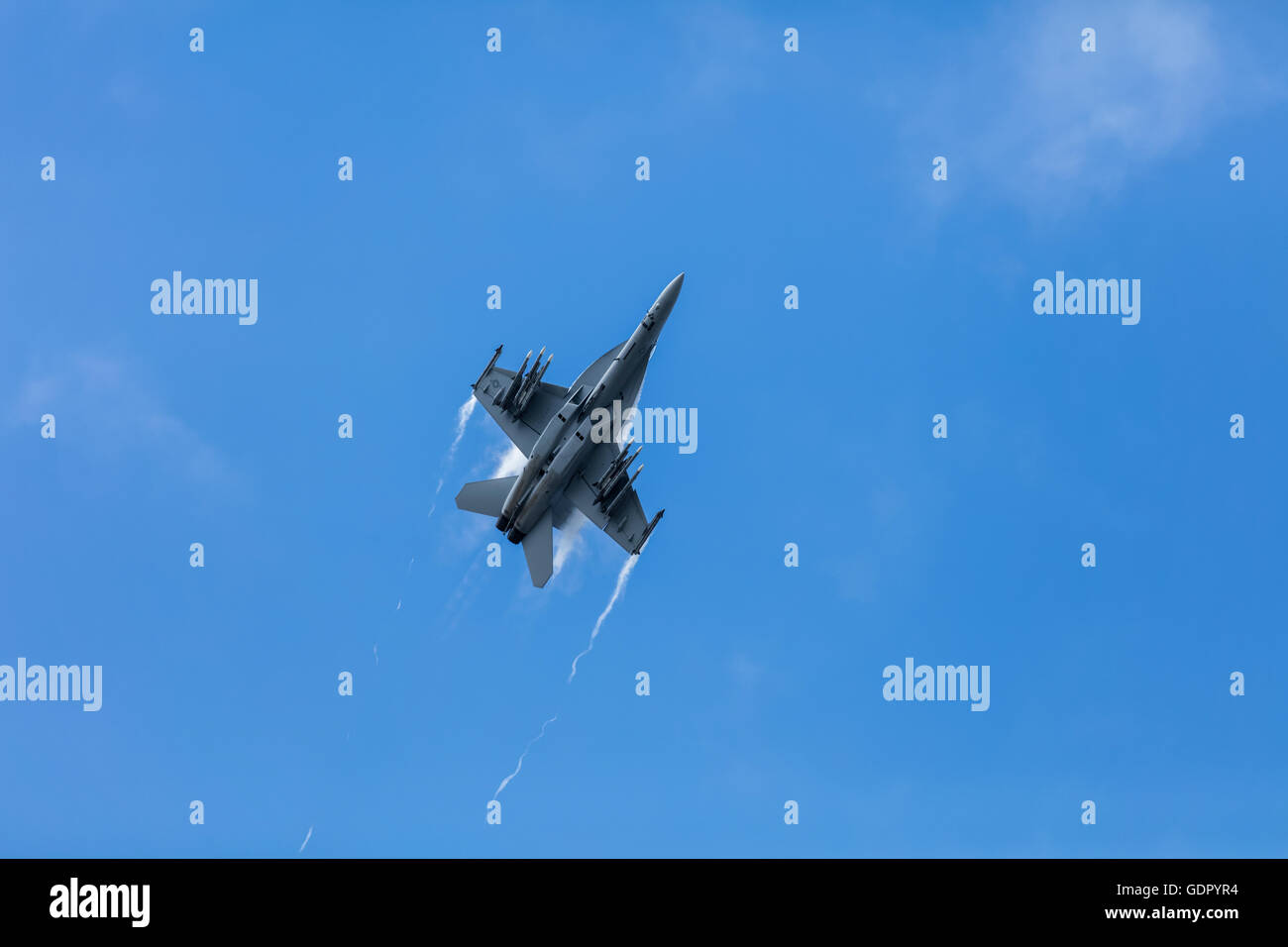 F/A 18 Super Hornet fighter plane in the sky with smoke trails from its wings Stock Photo
