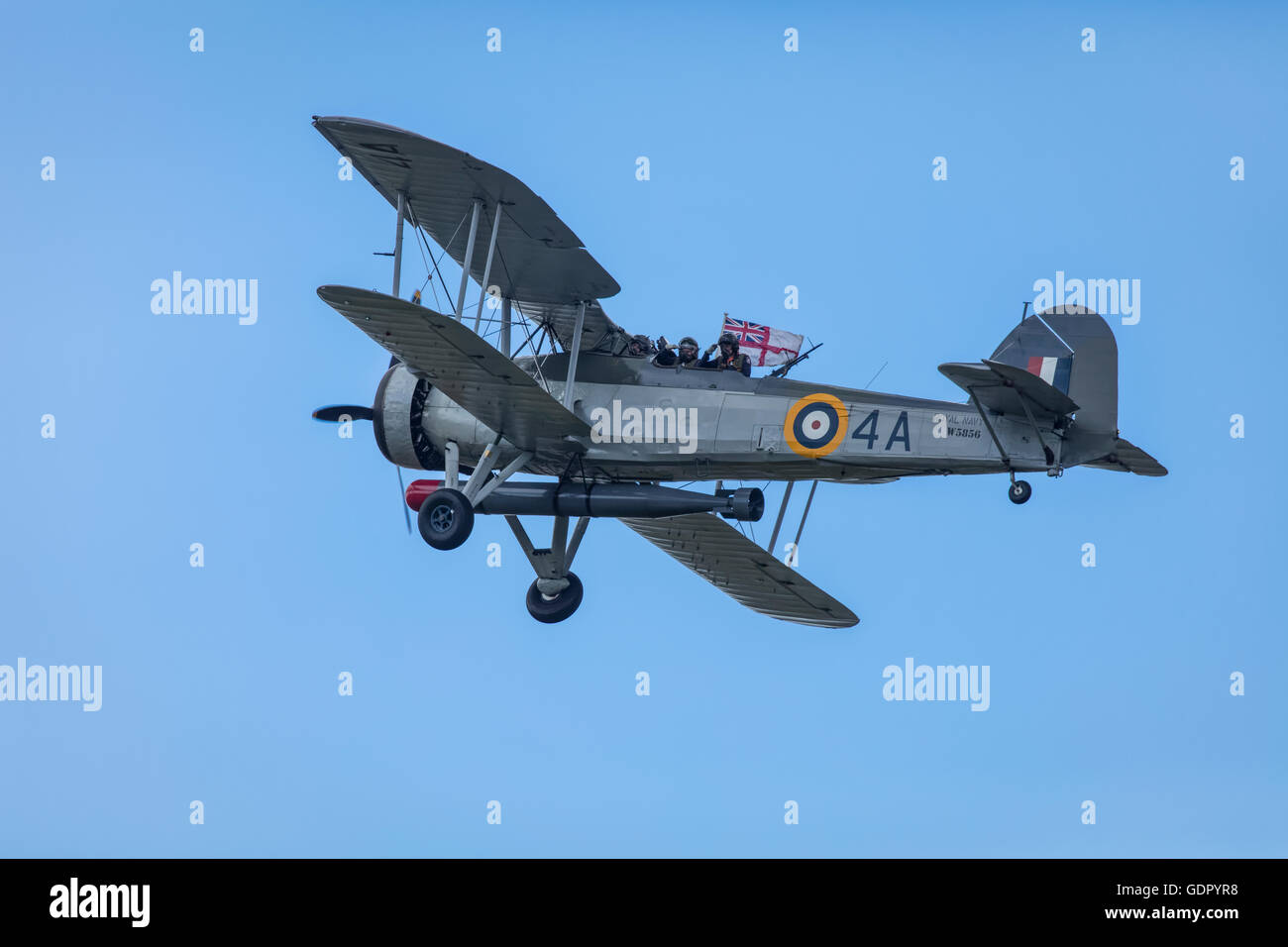 Royal Navy Swordfish bomber plane with missile in blue sky in flight
