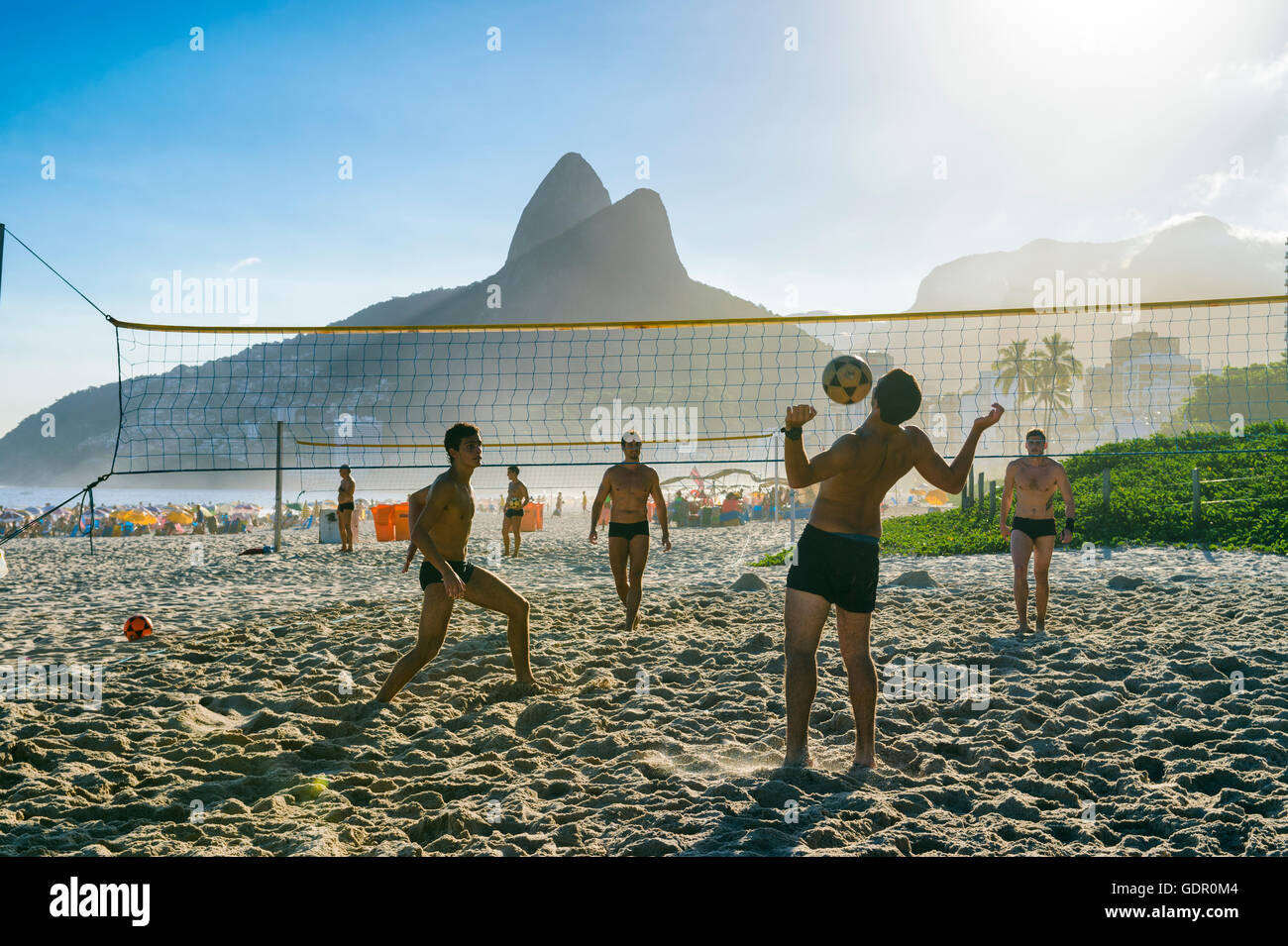 RIO DE JANEIRO - MARCH 27, 2016: Brazilians play futevôlei (footvolley, a sport combining football/soccer and volleyball). Stock Photo