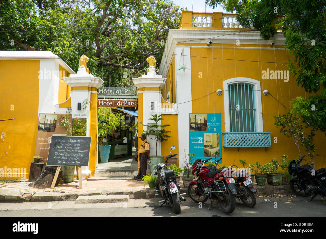 An old house, now a cafe, in Pondicherry, painted in bright yellow. Stock Photo