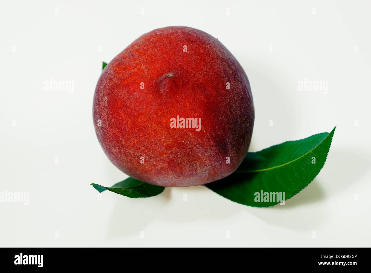 Ripe peach fruit with green leafs isolated on white background Stock Photo