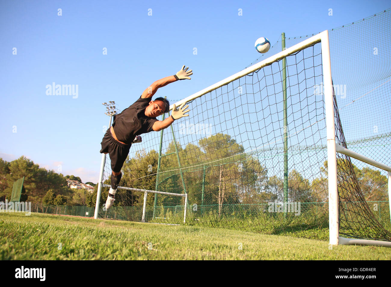 Goalkeeper trying to stop a ball Stock Photo Alamy