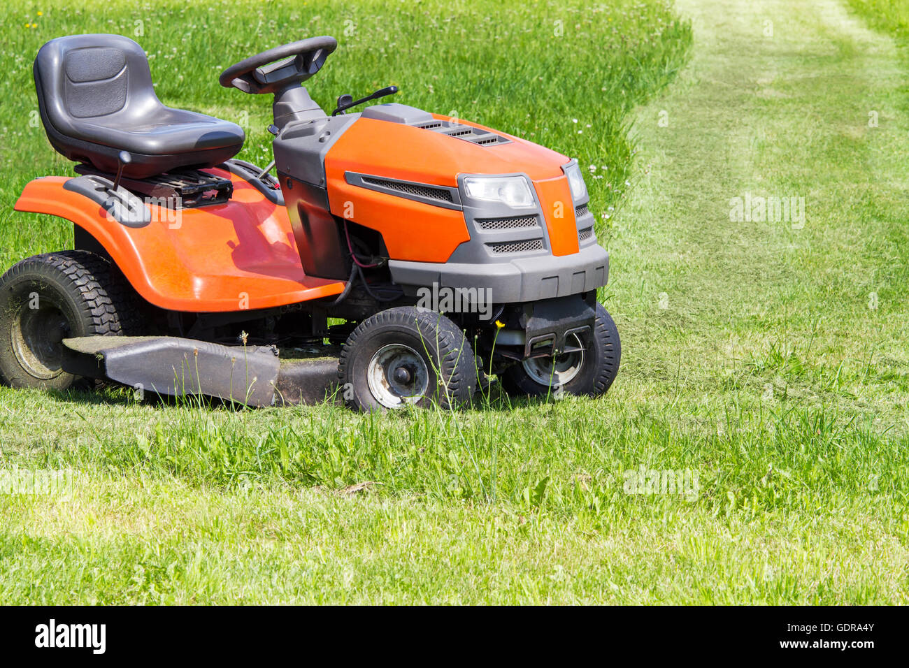 Lawn mower standing on green grass Stock Photo Alamy
