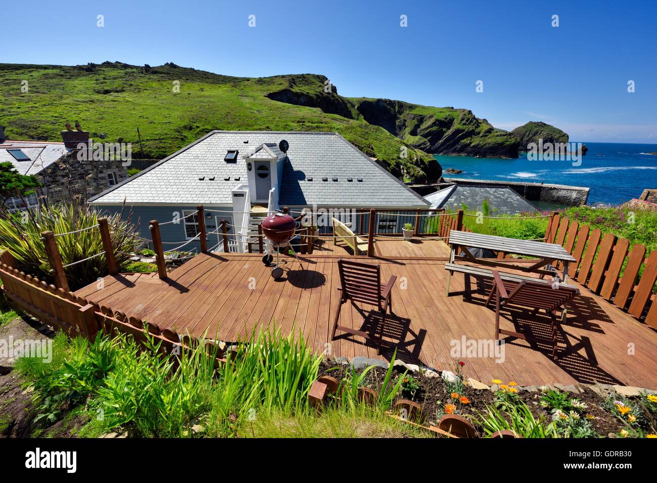 A barbecue decking area at the back of accommodation in Mullion Harbour Cornwall England UK Stock Photo