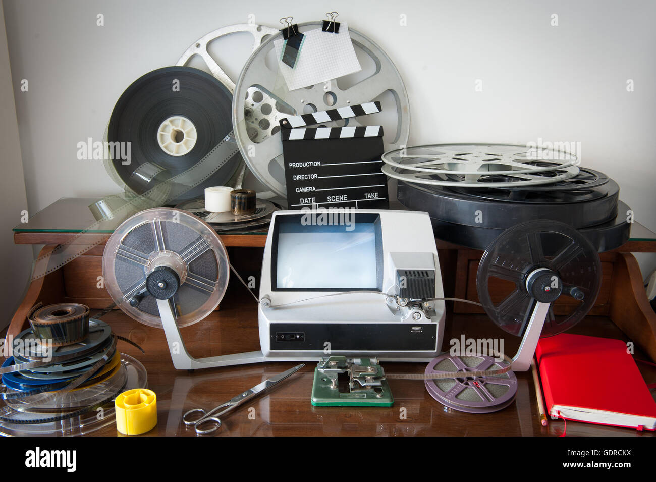 Desktop workspace for vintage movie editing with film reels, editing machine, splice, clapper Stock Photo