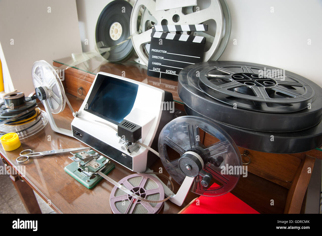 Desktop workspace for vintage movie editing with film reels, editing machine, splice, clapper Stock Photo