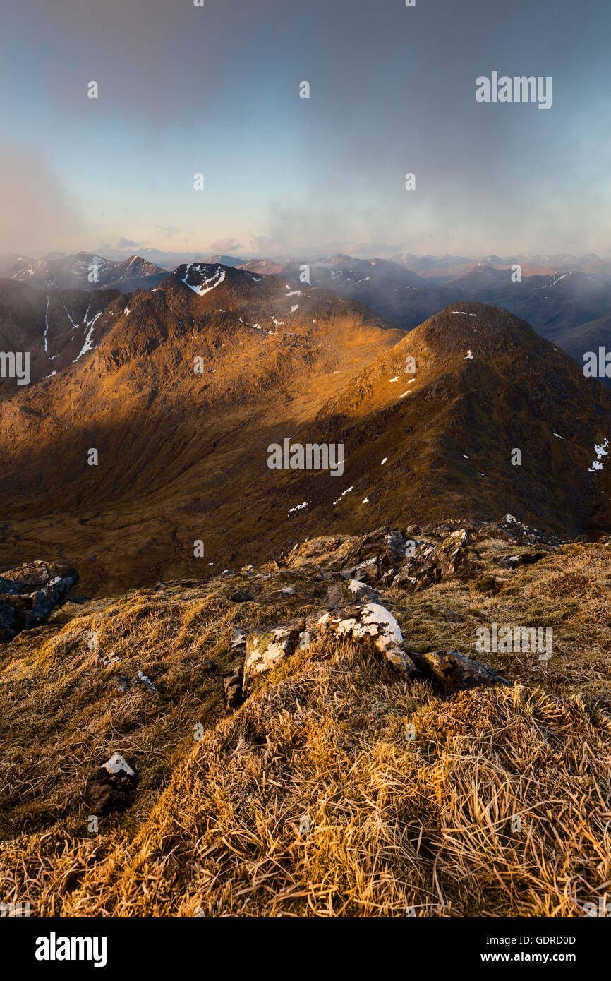 Sgurr na Carnach and Sgurr na Ciste Duibhe as seen from the frosty summit of Sgurr Fhuaran at sunrise Stock Photo