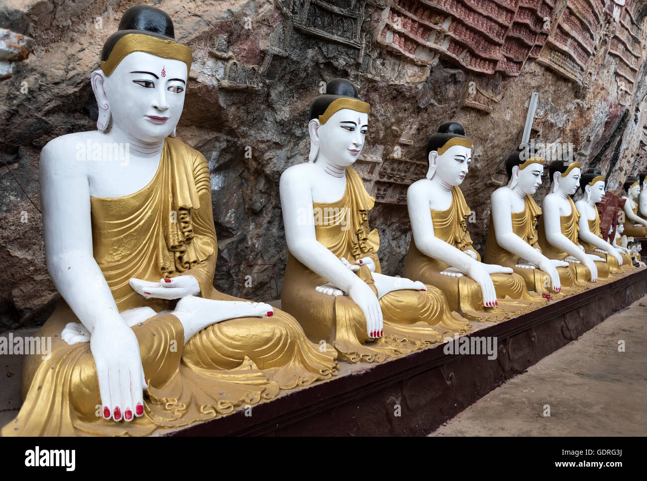 Line of Buddha statues at Kaw-goon Cave Temple, Mon State, Myanmar Stock Photo
