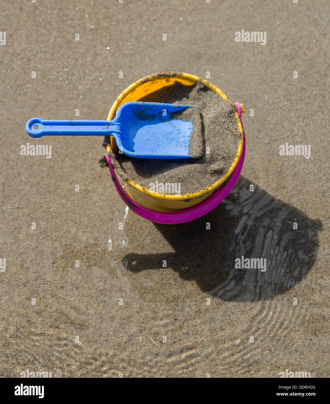 Toy Spade and Bucket on a Beach with sand. Stock Photo