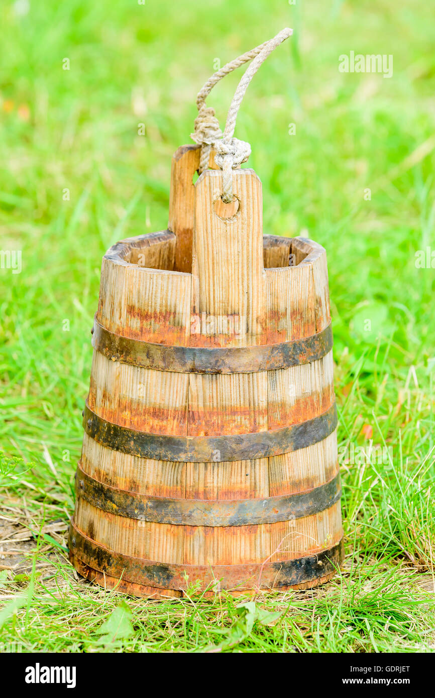 Vintage wooden water canister or flask with a small rope as handle on top. Metal hoops hold the wooden planks together. Stock Photo