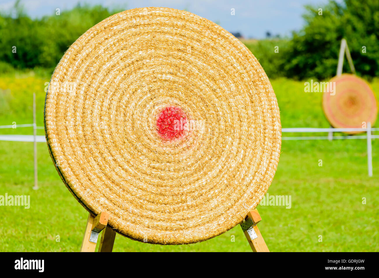 Outdoor archery target made of straw with a red dot as bullseye. Stock Photo