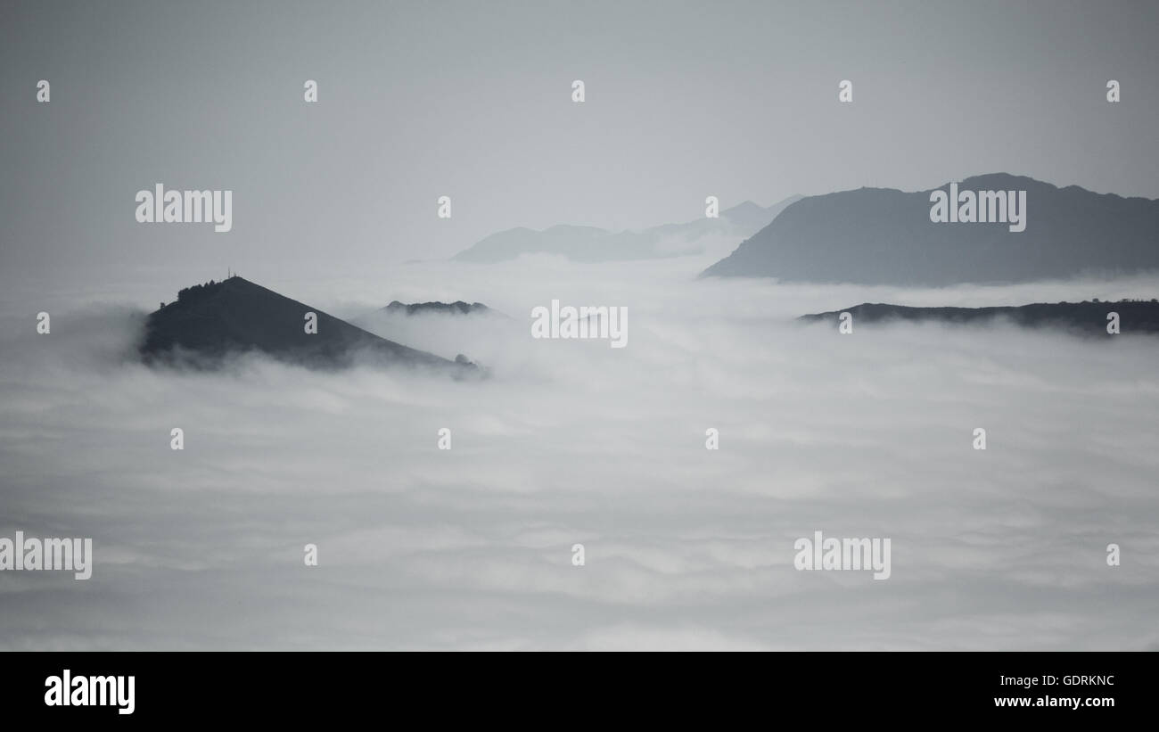 Over the clouds and fog among mountains in black and white Stock Photo ...