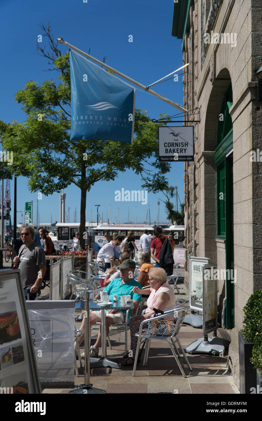 Tourists enjoy the Jersey sunshine whilst sitting at a Cafe within Liberation Square,St.Helier