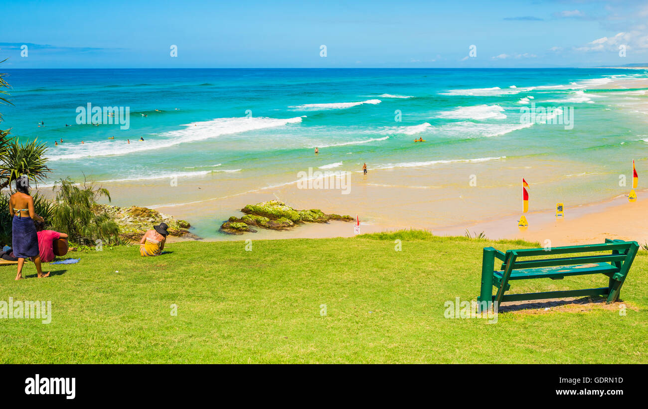People enjoying some music while relaxing on the grass overlooking a beautiful North Stradbroke Island beach Stock Photo