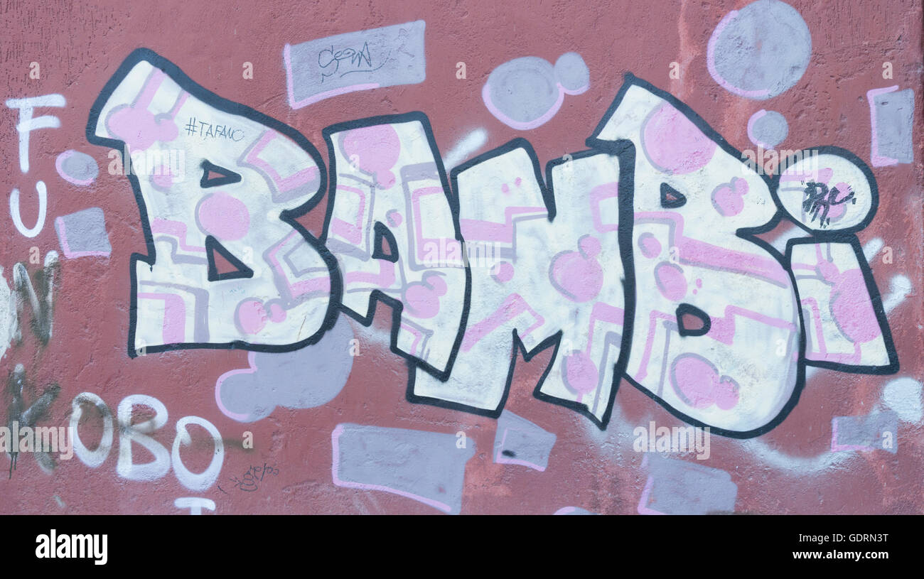 A powerful simple graffiti artwork, known as 'Bambin' which, is sprayed over a, cladded wall, and a large wooden, door. Stock Photo