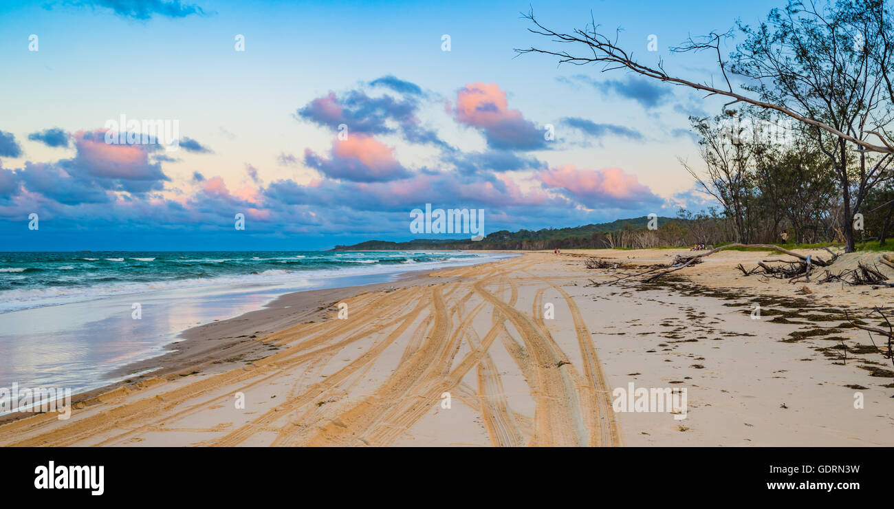 PInk clouds over North Stradbroke Island after the sun sets over the beach Stock Photo
