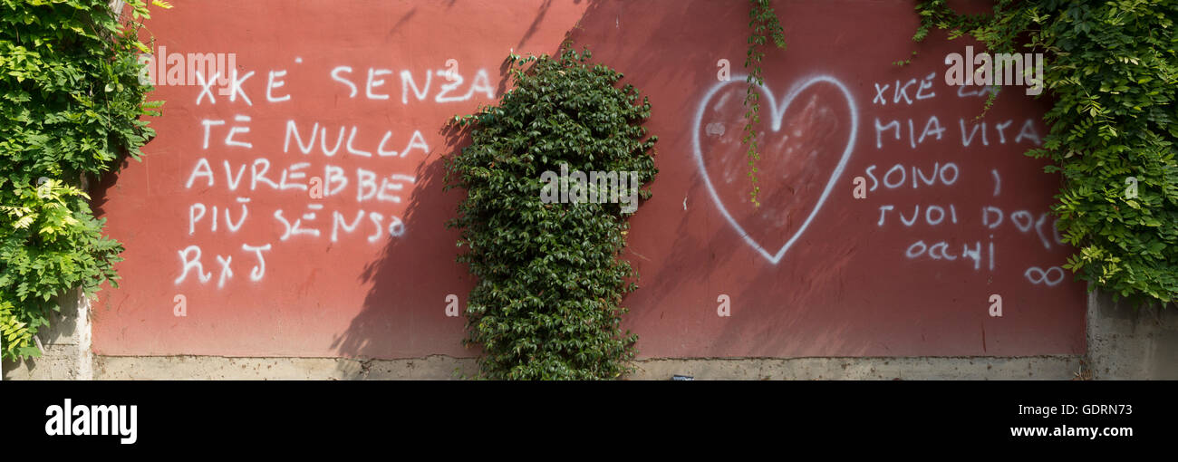 Graffiti,sprayed on a stone, Brick, wall, with Italian letters, on the brickwork with, white text shaded out, heart love bush, Stock Photo