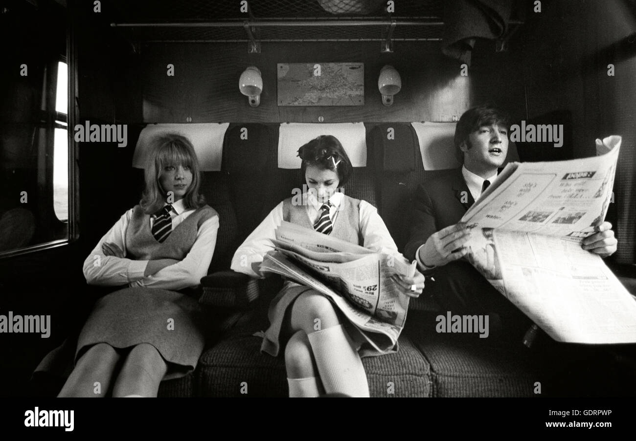 John Lennon with Prudence Bury and Pattie Boyd playing school girls on a Hard Days Night Train Stock Photo