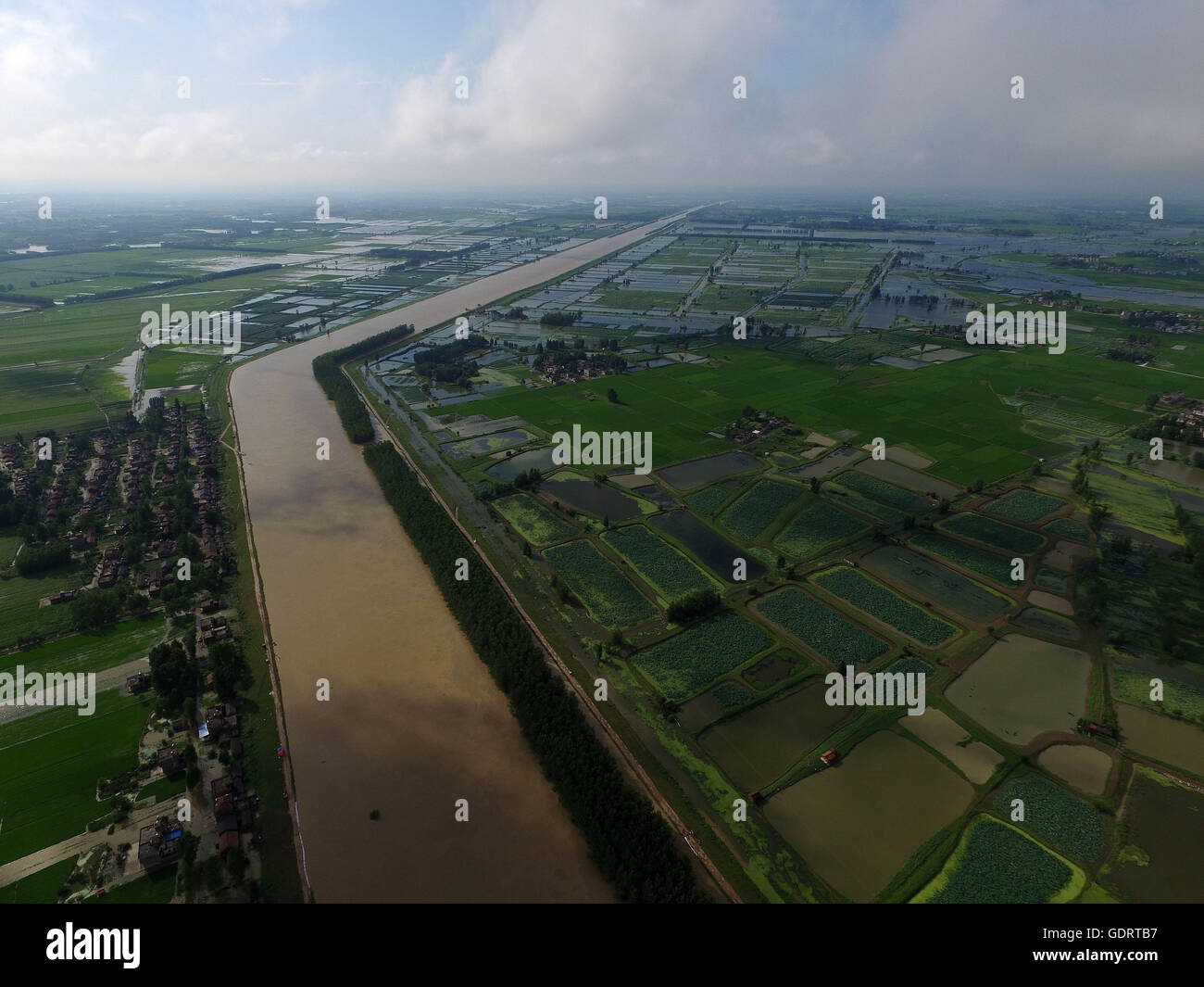 (160720) -- TIANMEN, July 20, 2016 (Xinhua) -- Aerial photo taken on July 20, 2016 shows the view of Hanbei River in Tianmen City, central China's Hubei Province. Tianmen civil affairs department relocated the local residents over safety concerns, as water in the nearby Hanbei River has reached its warning level due to recent heavy rain. (Xinhua/Xiong Qi) (wyl) Stock Photo