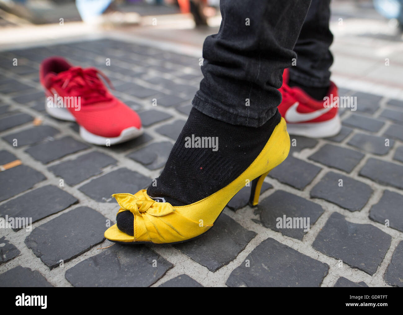 A participant wears yellow open toe pumps  during the High-Heel race in Frankfurt am Main, Germany, 16 July 2016. The race took place on occasion of the Christopher Street Day. Photo: Frank Rumpenhorst/dpa Stock Photo