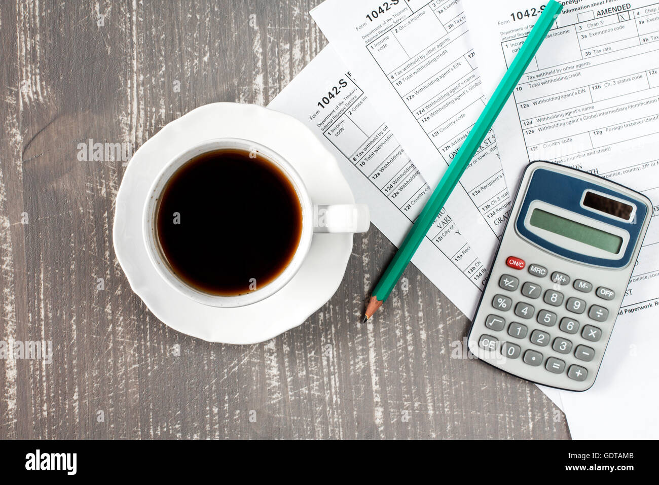 Coffee cup and forms 1042-s which confirms the payment of the tax in the United States Stock Photo