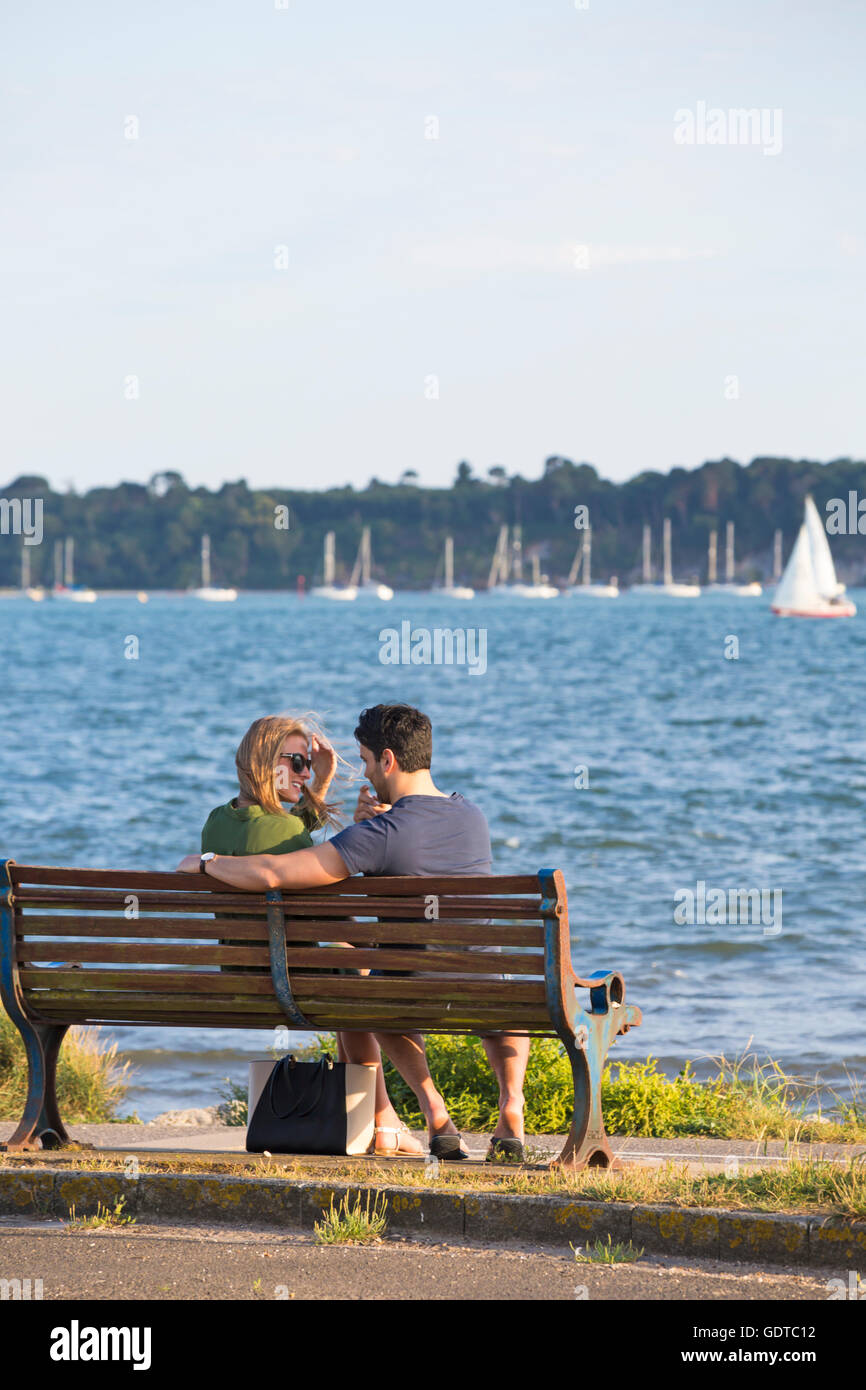 Couple sitting on bench by the sea at Baiter, Poole in July Stock Photo ...