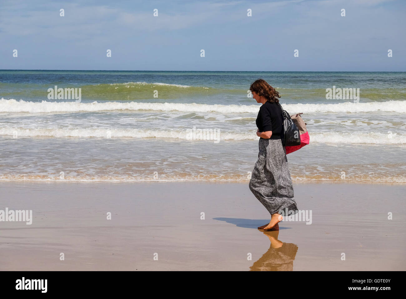 Woman walking along the beach in Cromer, Norfolk Stock Photo