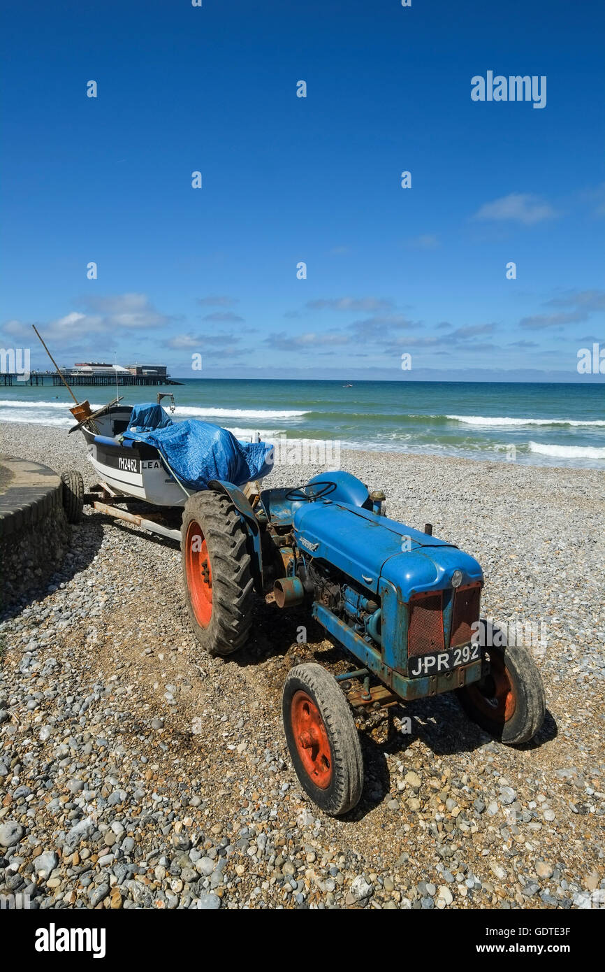 Old tractor and boat on the beach at Cromer in Norfolk Stock Photo