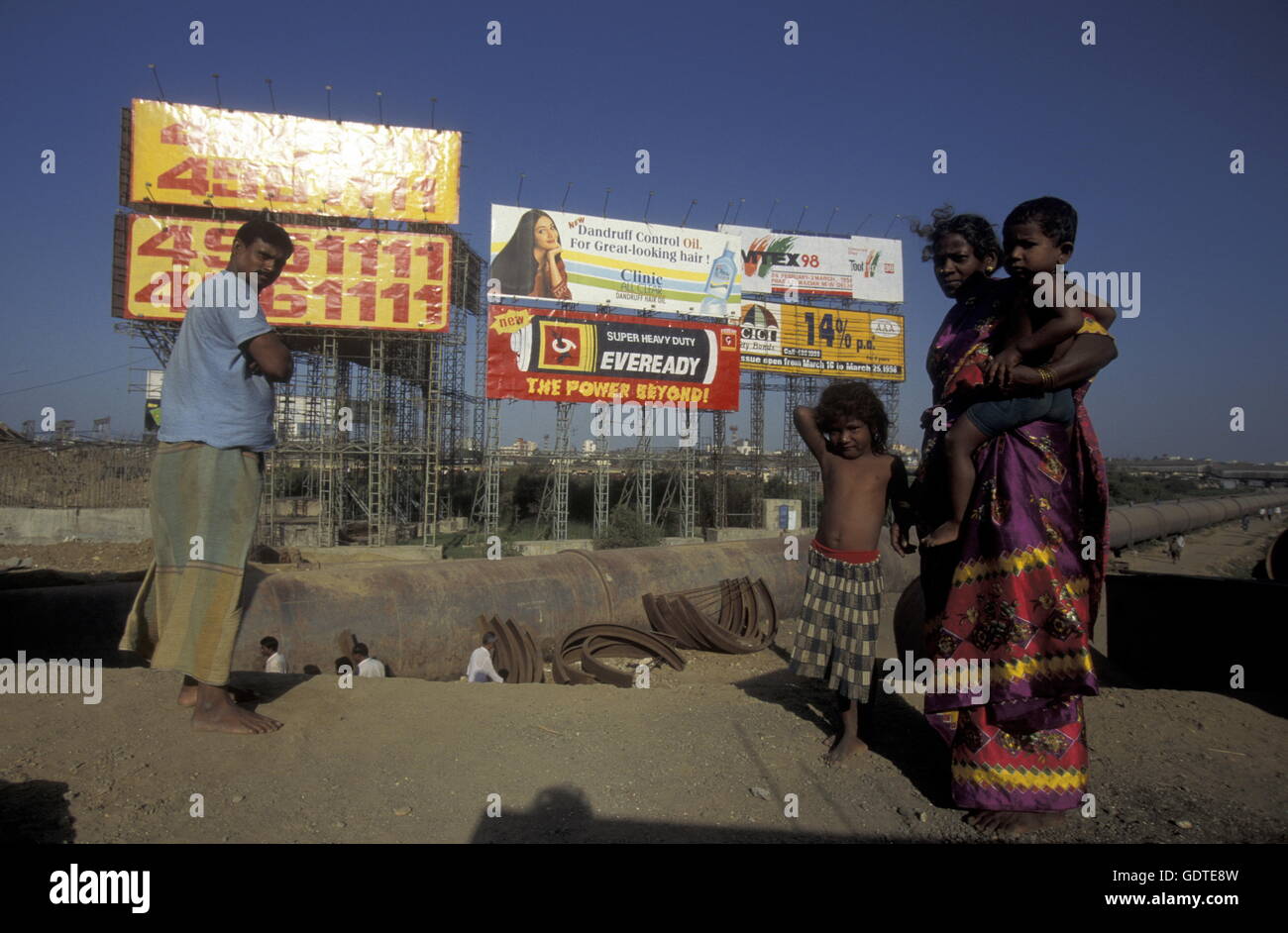 a Family in a slum and in front of promotions in the city of Bombay or Mumbai in India. Stock Photo