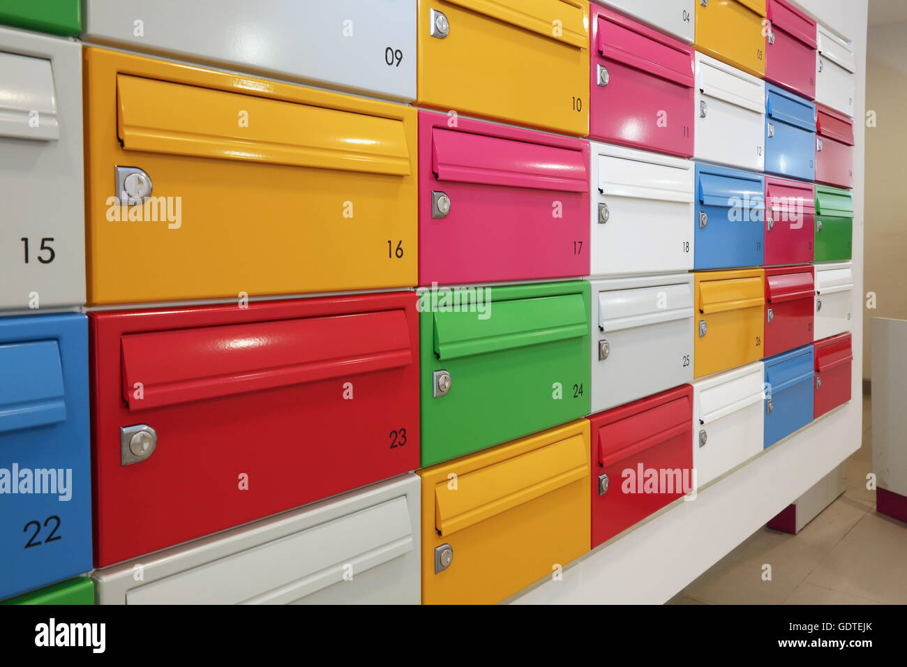 Close-up of multi-coloured mail boxes in the lobby of a fashionable new apartment block in London, UK Stock Photo