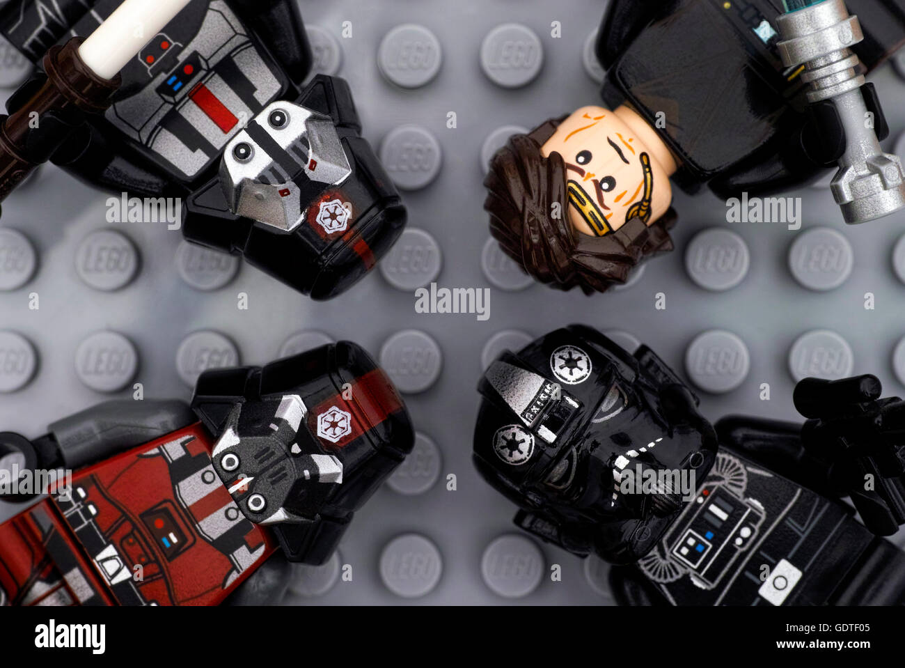 Four Lego Star Wars minifigures - Anakin Skywalker, TIE Pilot, black and red Sith troopers - on Lego gray baseplate background Stock Photo