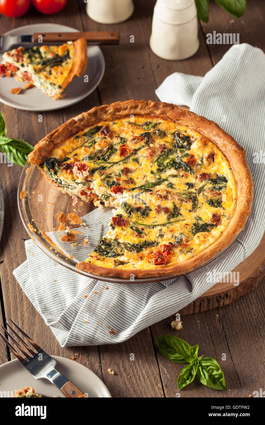 Homemade Cheesy Egg Quiche for Brunch with Spinach and Tomato Stock Photo