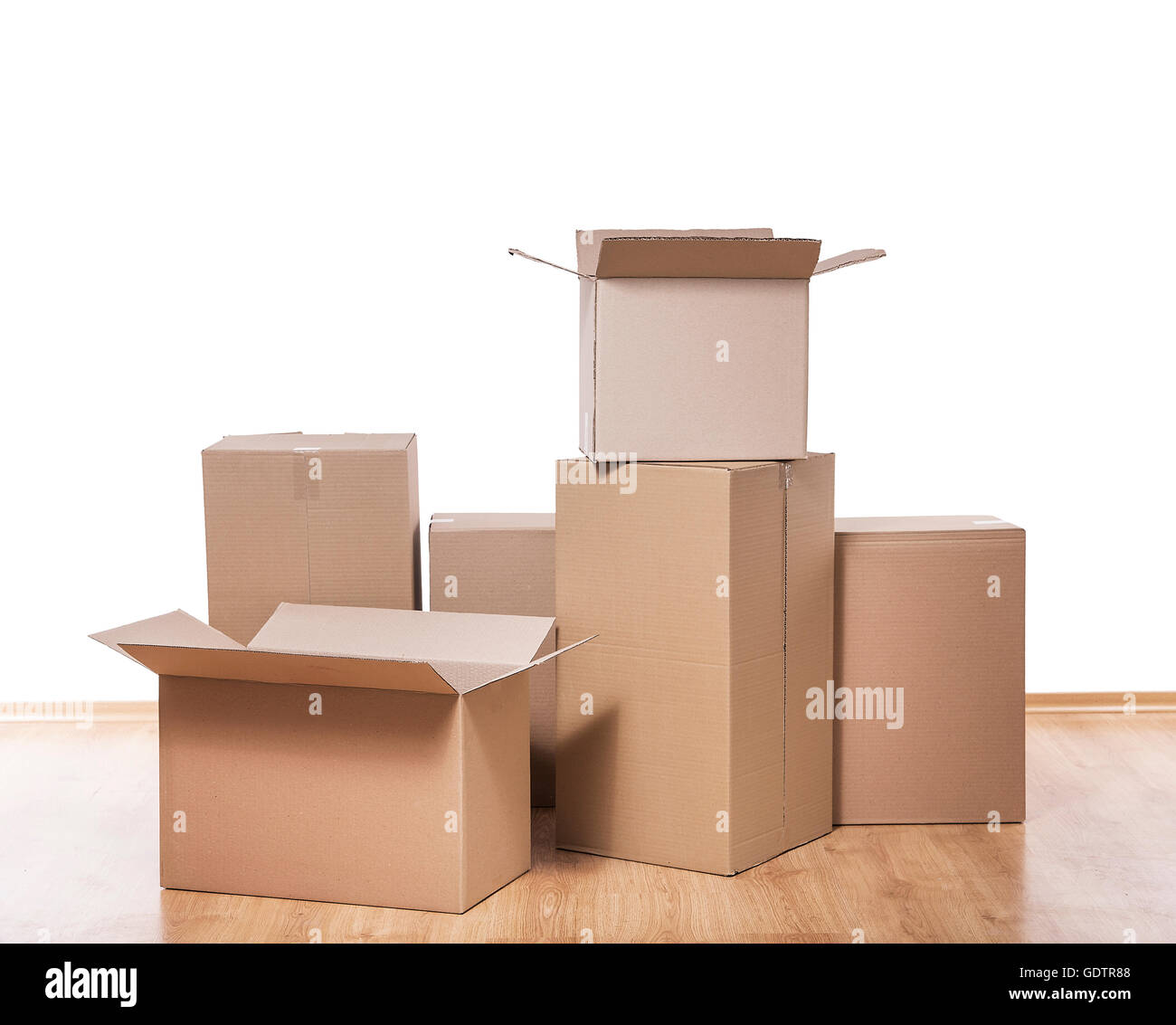 Empty room with a white wall and moving boxes on the floor. Stock Photo