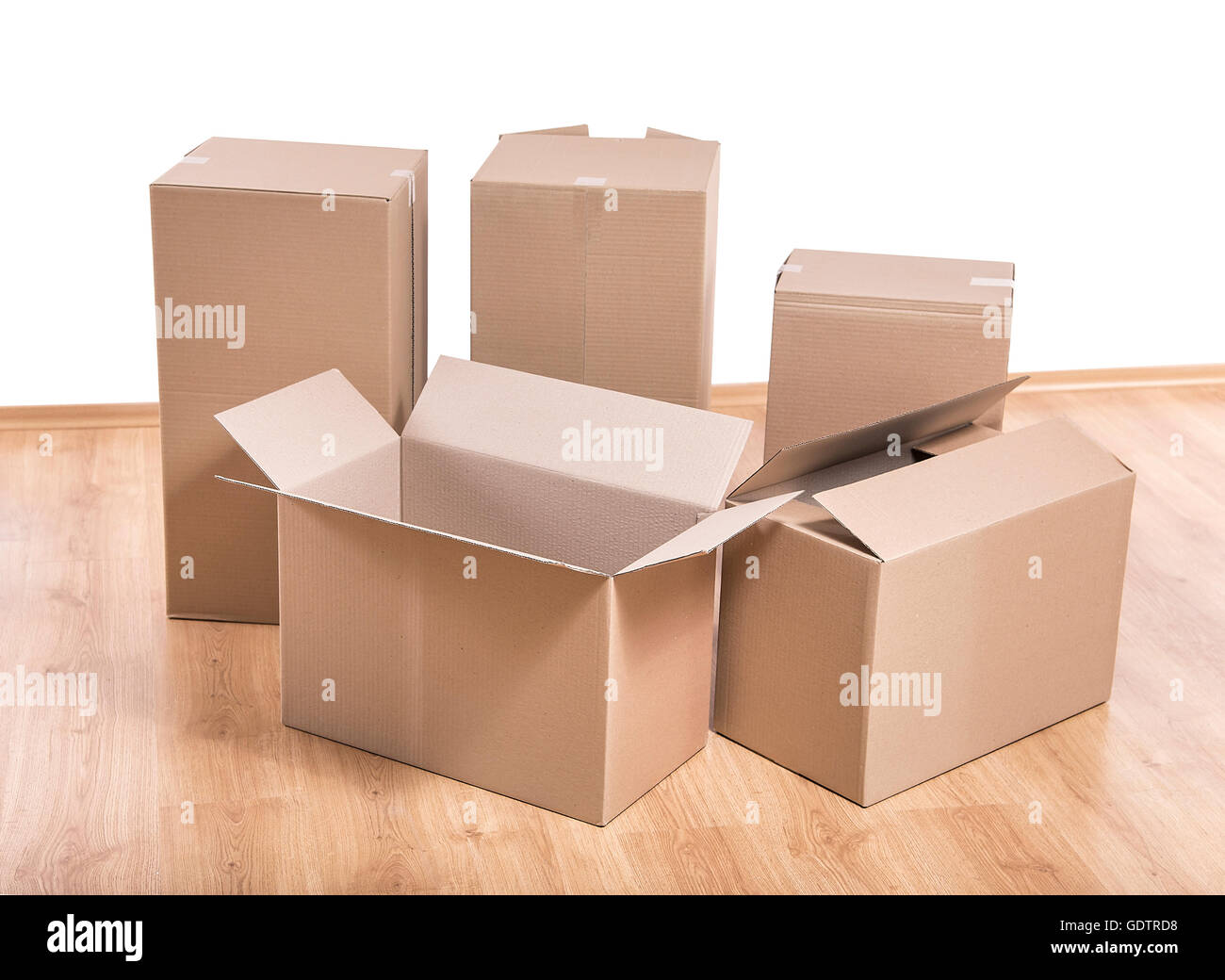 Empty room with a white wall and moving boxes on the floor. Stock Photo