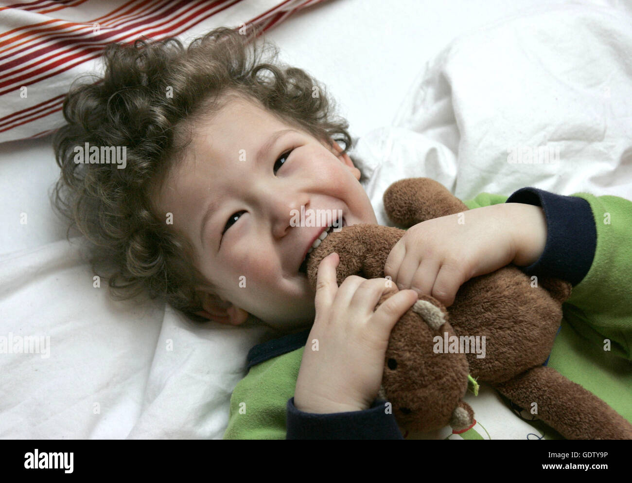 Laughing boy with stuffed animal Stock Photo