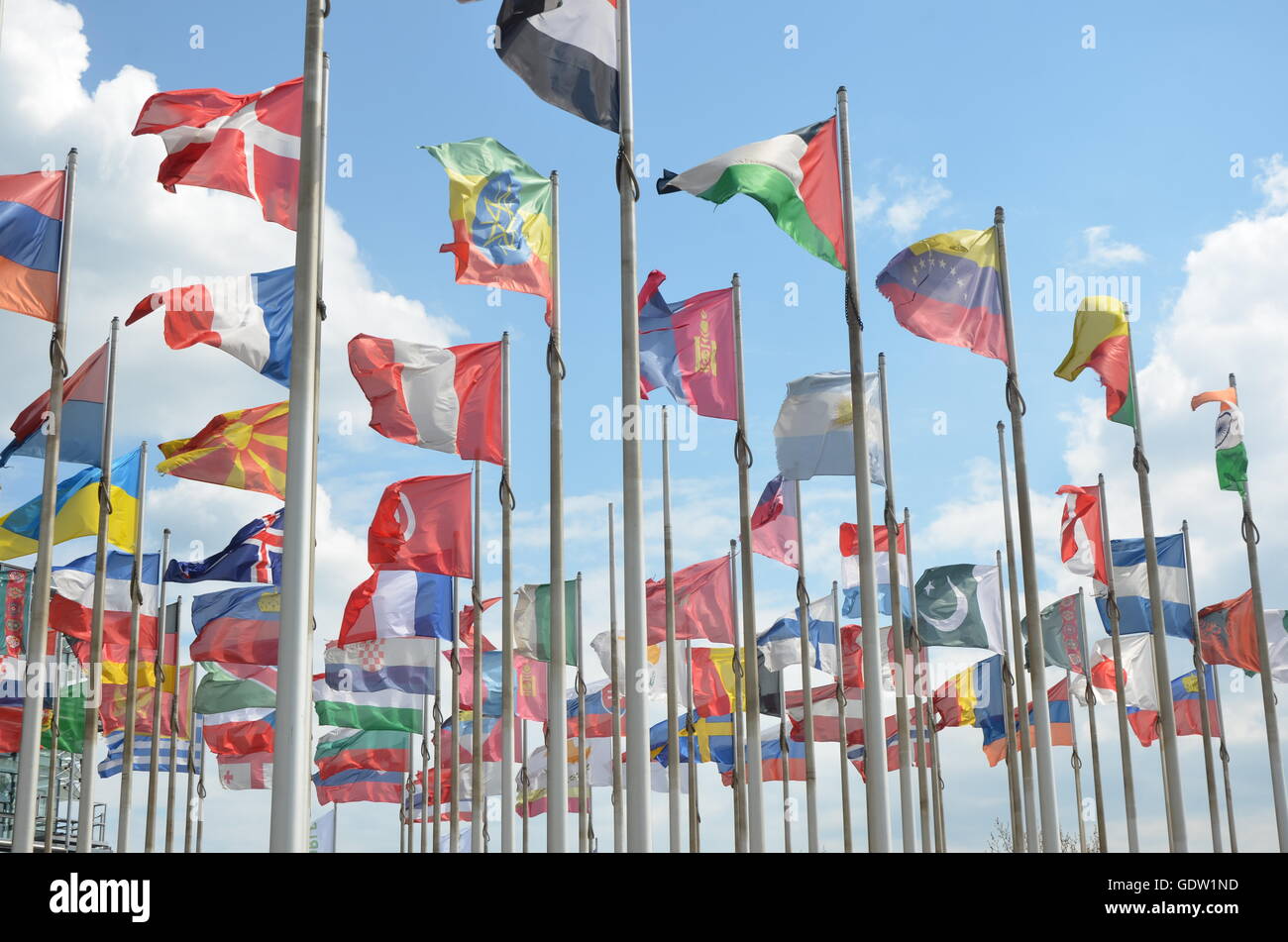flags, international, wind, poles, flag poles, clouds, blue sky, back light Stock Photo