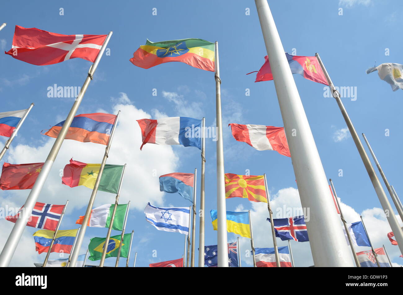 collection, flags, many, different nations, flag poles, clouds, blue sky, windy Stock Photo