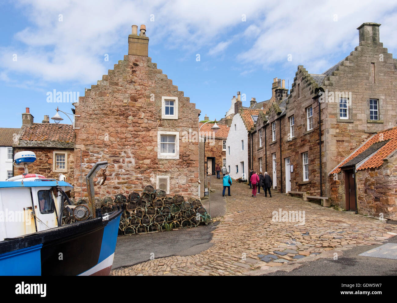 Old cottages by harbour with visitors walking on a cobbled street in Firth of Forth fishing village. Crail East Neuk Fife Fife Scotland UK Britain Stock Photo