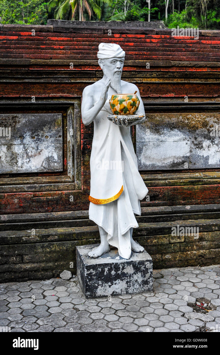 Sculpture of a priest holding a can of Holy Water in Tirta Embul temple ...