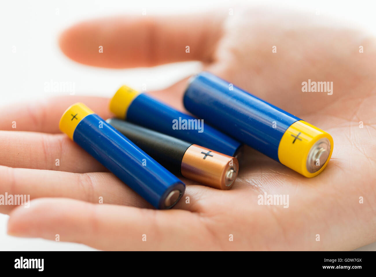 close up of hands holding alkaline batteries heap Stock Photo