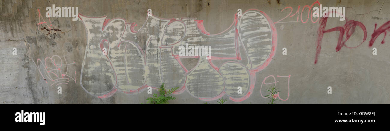 graffiti on a concrete, wall erosion with it ,slowly fading into it. Stock Photo