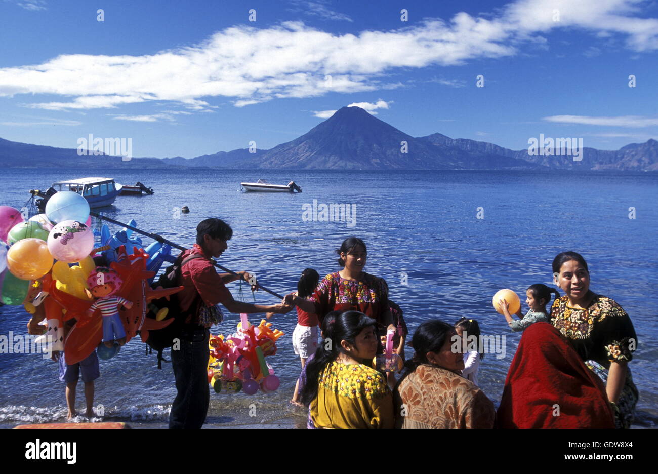 People at the coast of Lake Atitlan mit the Volcanos of Toliman and San Pedro in the back at the Town of Panajachel in Guatemala Stock Photo