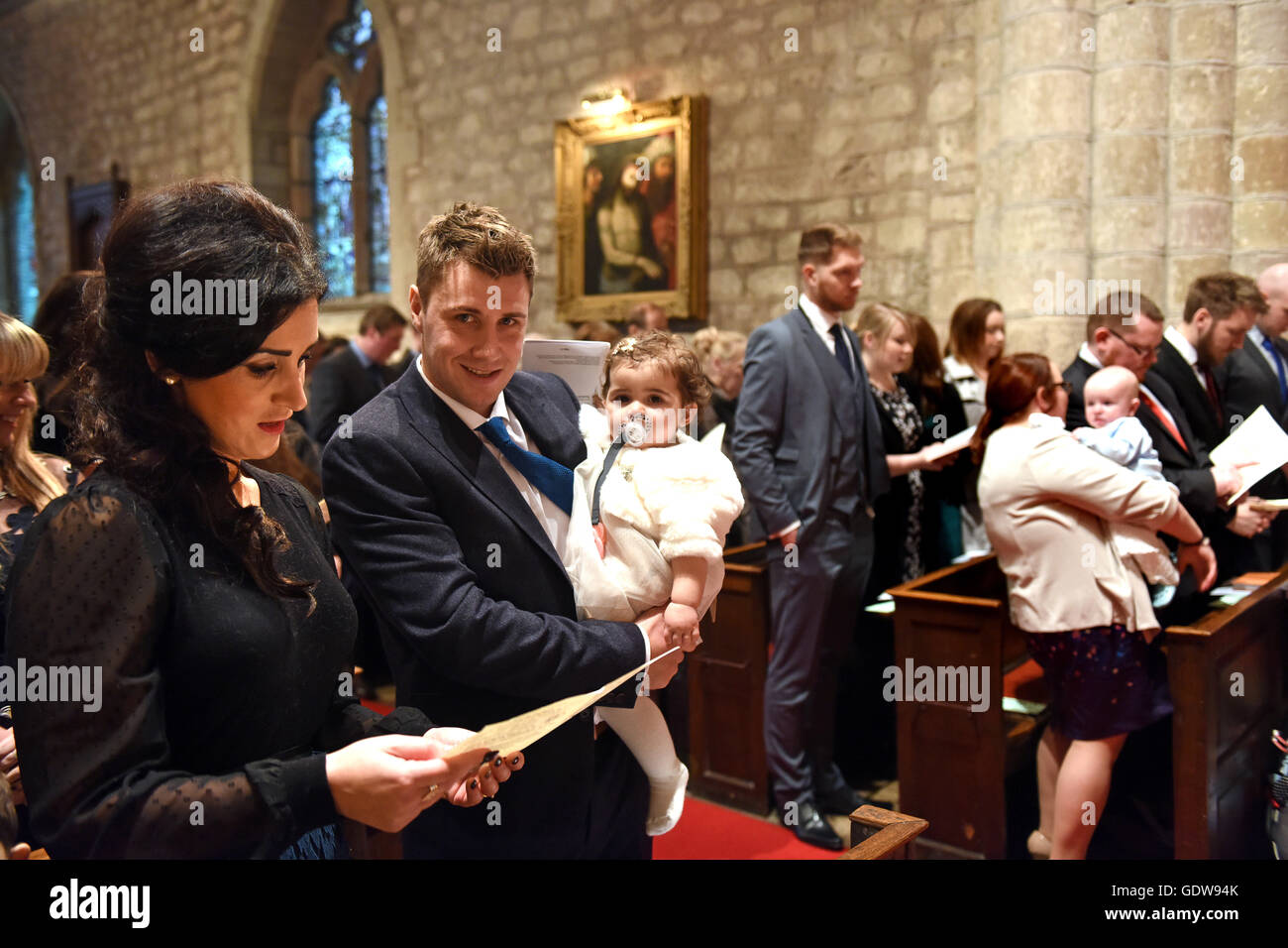 Young family in church for childs christening England Uk Stock Photo