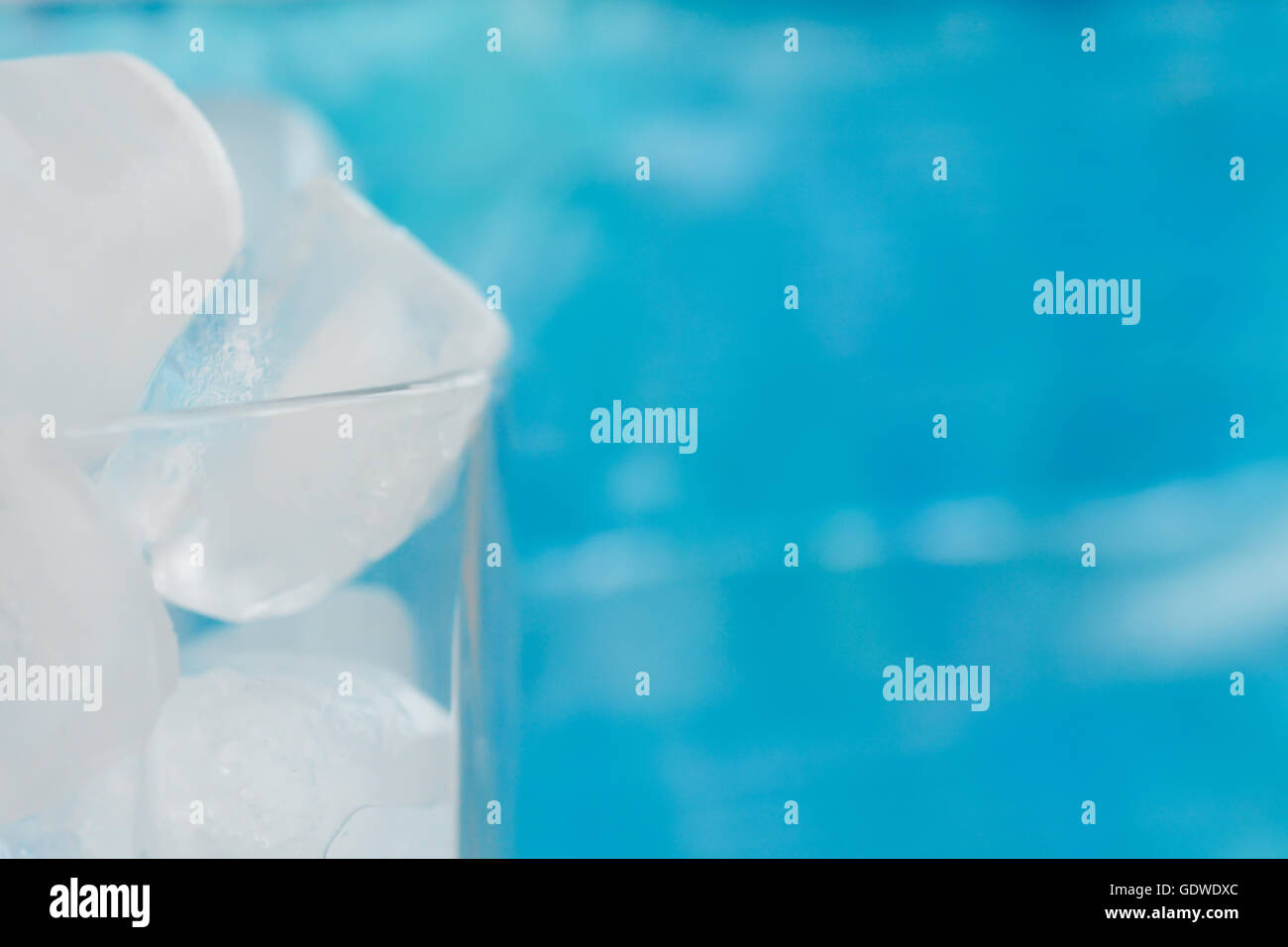 Ice cubes in a glass on blue background Stock Photo - Alamy